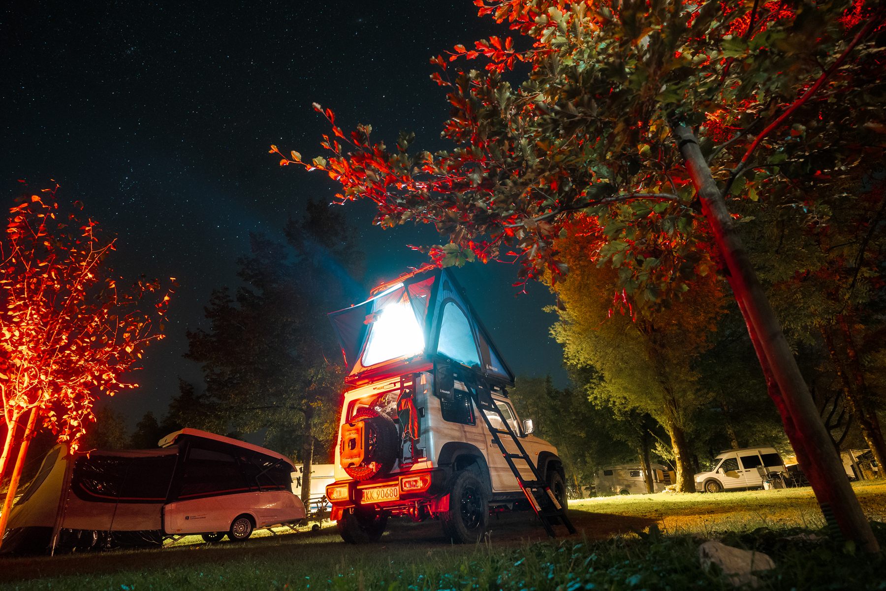Tienda de techo Snailer iluminada en un camping por la noche